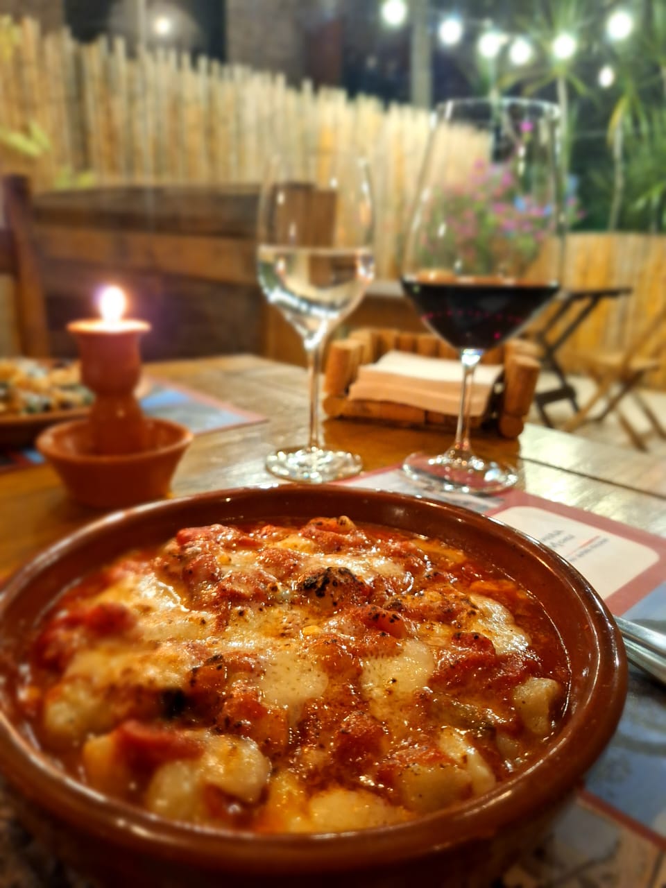 Taças de vinho e prato italiano sobre uma mesa preparada no salão